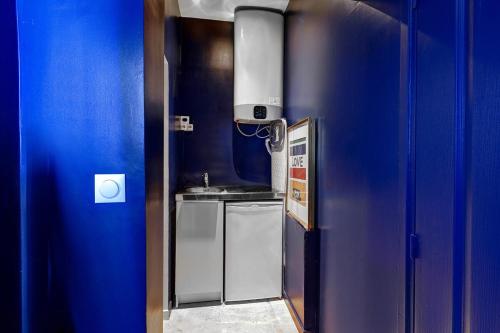 - une cuisine bleue avec évier et cuisinière dans l'établissement Sacré Coeur, Netflix & Chill by ecoflats, à Paris