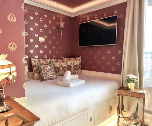 - une chambre avec un lit et une télévision murale dans l'établissement Appartement prestige a deux pas de Montparnasse 6P, à Paris