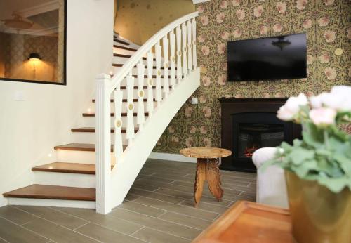 - un salon avec un escalier, une télévision et une cheminée dans l'établissement Appartement prestige a deux pas de Montparnasse 6P, à Paris