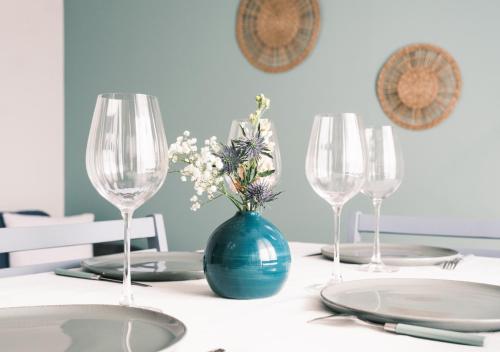 une table avec un vase bleu et des fleurs. dans l'établissement Vagues & Bord de Plage, à Biscarrosse