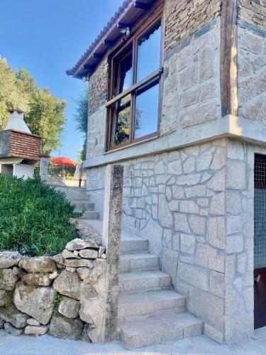 a stone house with stairs leading up to a window at O Barraco Martins T1 in Mondim de Basto