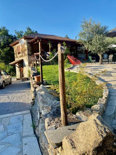 a house with a wooden pole in the grass at O Barraco Martins T1 in Mondim de Basto