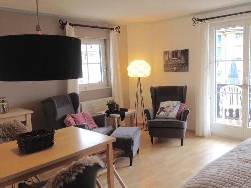 a living room with chairs and a bed and a table at Chasa Valluns 5306 - Studio in Vulpera