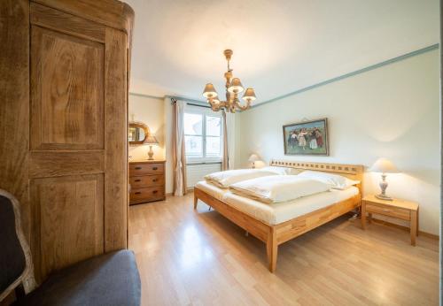 a large bedroom with a bed and a chandelier at Chasa Valluns 5302 - WG in Vulpera