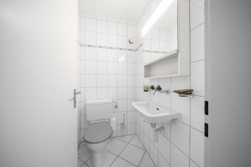 a white bathroom with a toilet and a sink at Chasa Valluns 5302 - WG in Vulpera