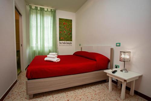 een slaapkamer met een rood bed en een tafel met een lamp bij Acquamarina in Grottammare