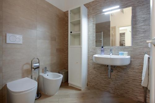 a bathroom with a sink and a toilet and a mirror at Carlo Alberto 46 in Pavia