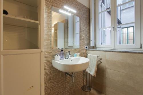 a bathroom with a white sink and a mirror at Carlo Alberto 46 in Pavia