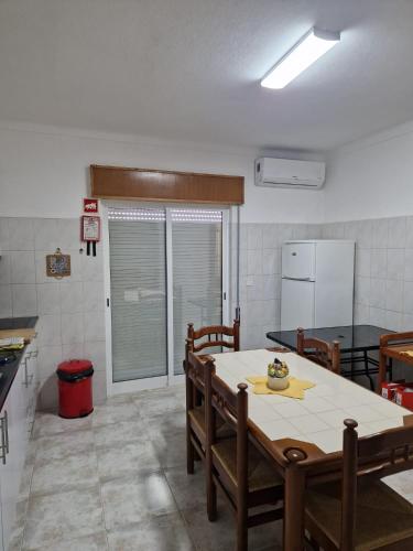a kitchen with a table and chairs and a refrigerator at Algarve Apartment Manta Rota in Vila Nova De Cacela