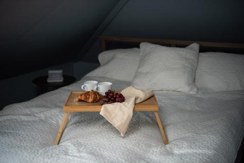 een dienblad met eten op een bed met twee kopjes en een bord eten bij Spacious apt, Big roof terrace, Free parking in Stavanger