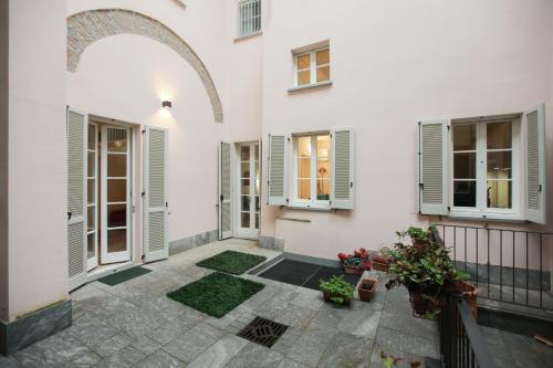 a courtyard of a white house with windows and plants at Carlo Alberto 46 in Pavia