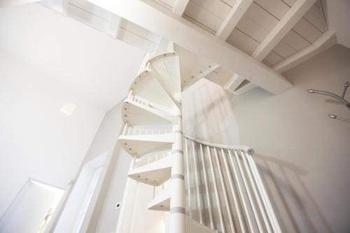 a white spiral staircase in a room at Carlo Alberto 46 in Pavia