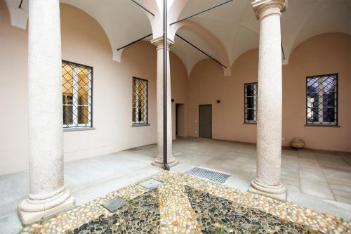 an empty room with columns and a mosaic floor at Carlo Alberto 46 in Pavia