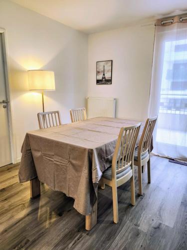 une table à manger avec quatre chaises et une lampe dans l'établissement Modern 2BR balcony secured parking metro 14, à Saint-Ouen