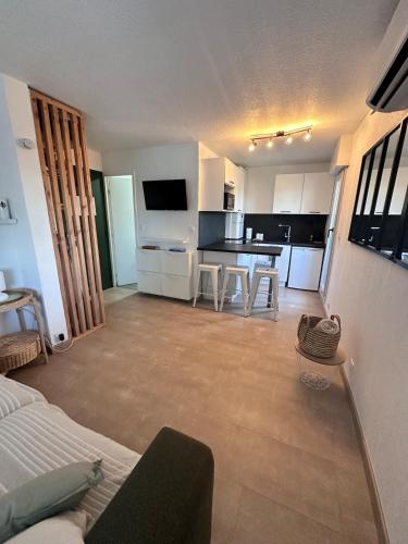 un salon avec un canapé et une cuisine dans l'établissement Studio Cosy en bord de mer, à La Grande Motte