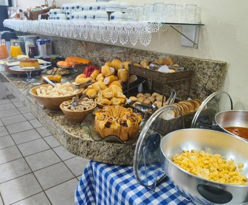 a buffet with many different types of food on a table at Hotel Minastur in Capitólio