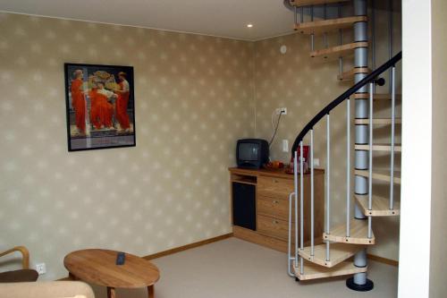 a living room with a spiral staircase and a table at Nynäsgården Hotell & Konferens in Nynäshamn