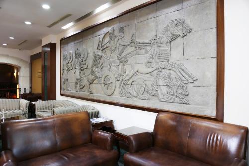 a lobby with chairs and a large painting on the wall at Benler Otel Laleli ISTanbul in Istanbul