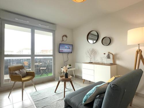 un salon avec un canapé et une télévision dans l'établissement Central, Balcony, Private parking, à Villefranche-sur-Saône