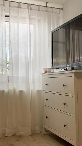 卡尔夫CASA DEL SOL - Neu ausgestattete Ferienunterkunft mit Parkplatz und E-Auto Ladestation的窗户旁的梳妆台,上面有电视