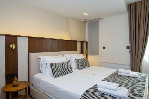 a bedroom with a large white bed with towels on it at Almi-Cove Hilltop Villas in Almirida