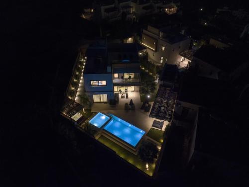 an overhead view of a house with a pool at night at Almi-Cove Hilltop Villas in Almirida