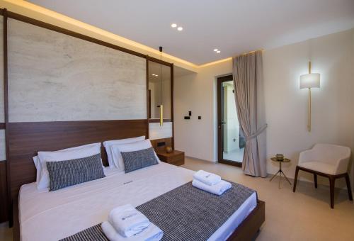a bedroom with a large bed with two towels on it at Almi-Cove Hilltop Villas in Almirida