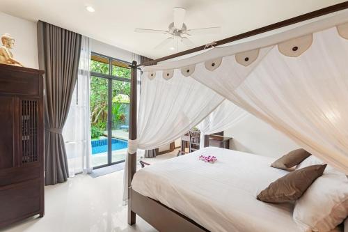 a bedroom with a bed with a canopy at Villa Anatta for your serene vacation in Ban Saiyuan (1)