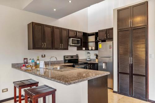 a kitchen with brown cabinets and a counter top at 2 BD Condo with Pool in Ocotal