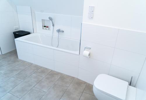 a white bathroom with a tub and a toilet at AMBERG [APART] - Wohnung [CITY] - Wohnraum auf Zeit in Amberg