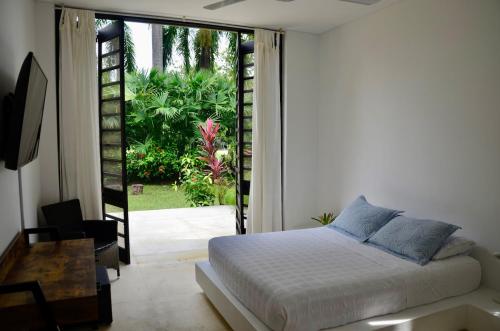 a bedroom with a bed and a sliding glass door at Villa en Club Campestre Mesa de Yeguas in Anapoima