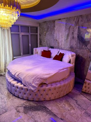 - une chambre avec un grand lit dans une pièce à éclairage violet dans l'établissement Golden house 2 - Jacuzzi, à Rouen