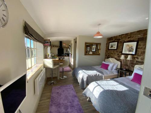 a room with two beds and a sink in it at Lavender cottage in Gloucester