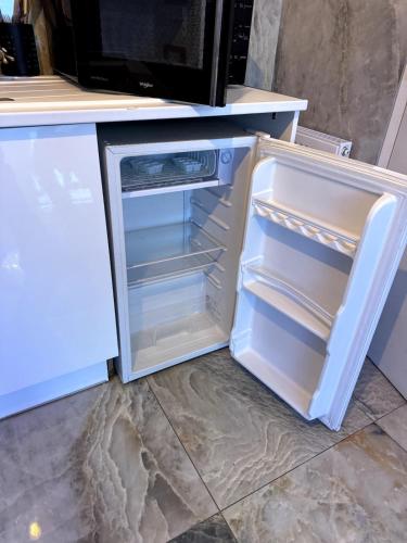 un réfrigérateur vide avec sa porte ouverte dans une cuisine dans l'établissement Golden house 2 - Jacuzzi, à Rouen