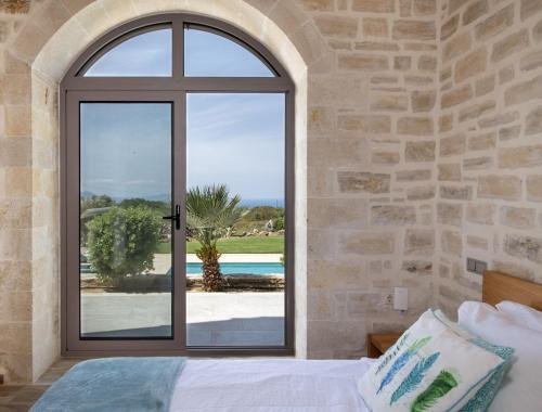 a bedroom with a window with a view of the ocean at Villa AuroraLuxurius Living in Prinés
