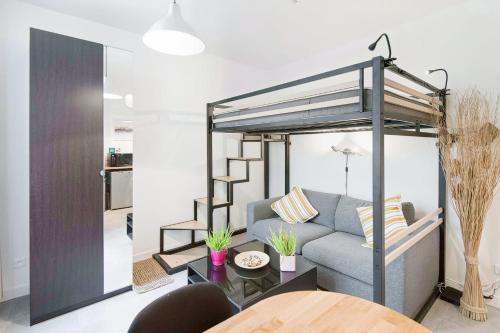 - un salon avec un canapé et une mezzanine dans l'établissement Charming Studio Steps Away from Montmartre, à Paris
