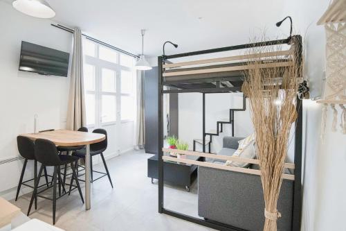 Cette chambre comprend une mezzanine et une table. dans l'établissement Charming Studio Steps Away from Montmartre, à Paris