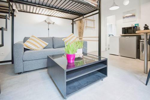 un salon avec un canapé et une table dans l'établissement Charming Studio Steps Away from Montmartre, à Paris