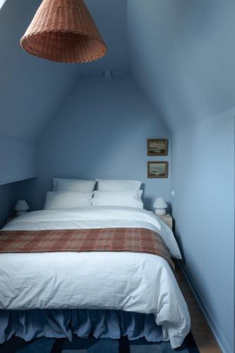 une chambre avec un lit avec un mur bleu dans l'établissement Appartement de charme dans le centre de Rouen, à Rouen