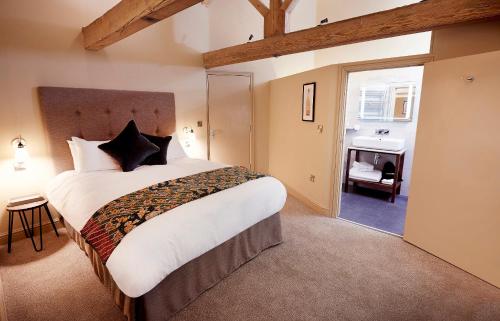 a bedroom with a large bed and a bathroom at The Tickled Trout in Maidstone