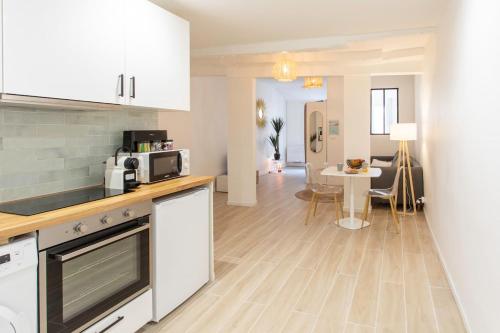 une cuisine avec des armoires blanches et une table dans une pièce dans l'établissement #16 1BDR Flower market, Old Town, 1min beach AC, à Nice