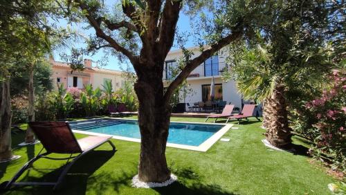 - une piscine dans une cour avec un arbre dans l'établissement Villa Mona 