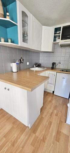 une cuisine avec des armoires blanches et un plancher en bois dans l'établissement Charming 2 rooms, air conditioning, terrace, WiFi, à Vallauris