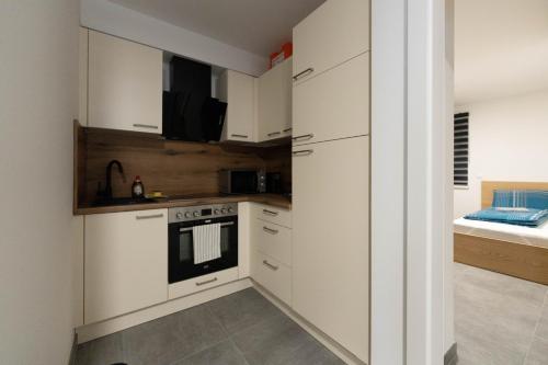 a kitchen with white cabinets and a stove at Ranshofen Zimmervermietung Projektentwicklungs GmbH in Ranshofen