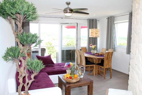 a living room with a purple couch and a table at Appartement In Schalkenmehren Mit Schönem Balkon in Schalkenmehren