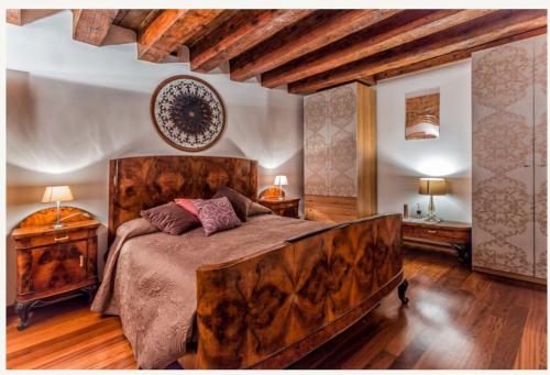 una camera da letto con un letto grande con testiera in legno di Suite Haven in Venice with private SPA a Venezia