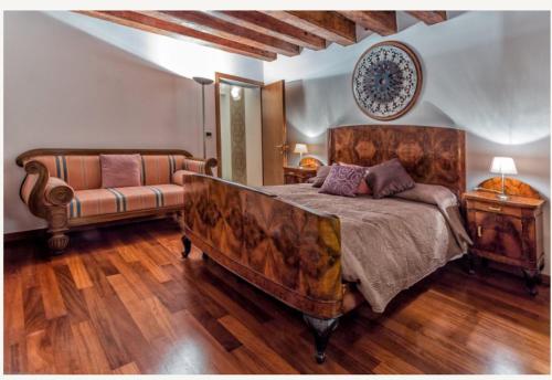 une chambre avec un grand lit et un canapé dans l'établissement Suite Haven in Venice with private SPA, à Venise