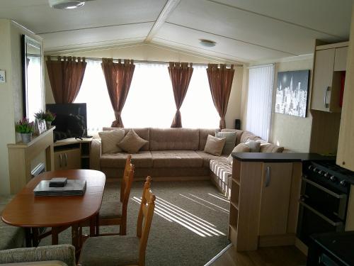 a living room with a couch and a table at Seaview Burgundy 8 Berth Central heated in Ingoldmells