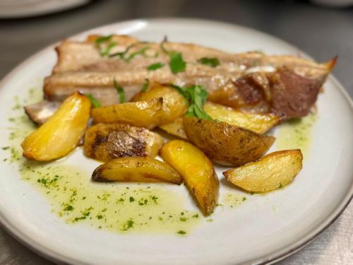 a plate of food with meat and potatoes on a table at Golden Lisbon Hotel in Lisbon