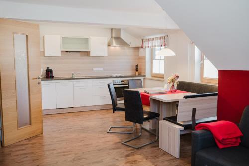a kitchen and living room with a table and chairs at Pension Bacherhof in Mariapfarr
